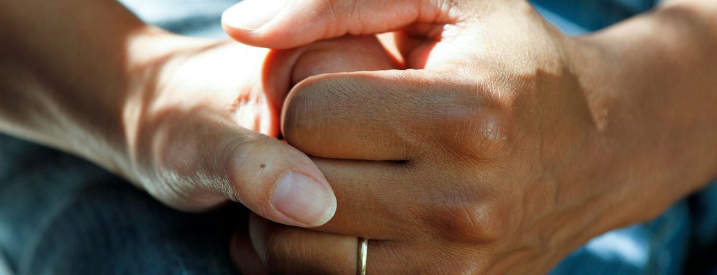 Une personne tenant la main d’une autre