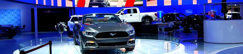 A car show stand staged with large video screens and lighting