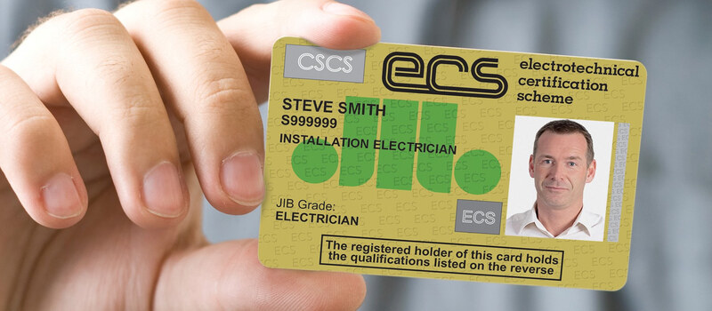 A hand holding up a sample ECS gold card with a cardholder’s photo
