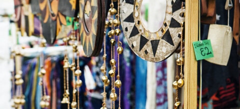 Fair trade crafts: painted wall hangings, a mosaic mirror and brass bells