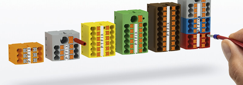 A row of terminal blocks in ascending sizes, with a wire being inserted into the largest