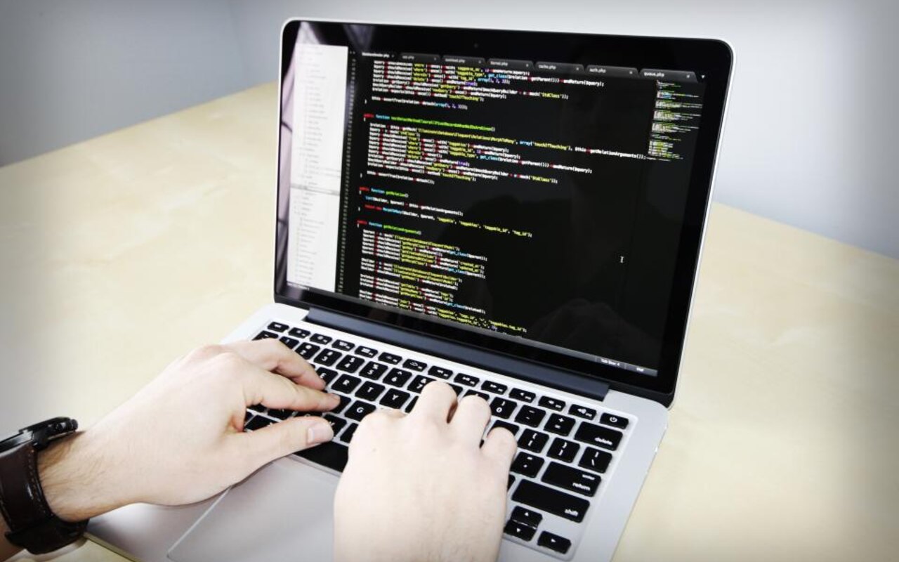 Mains tapant du code sur un ordinateur portable